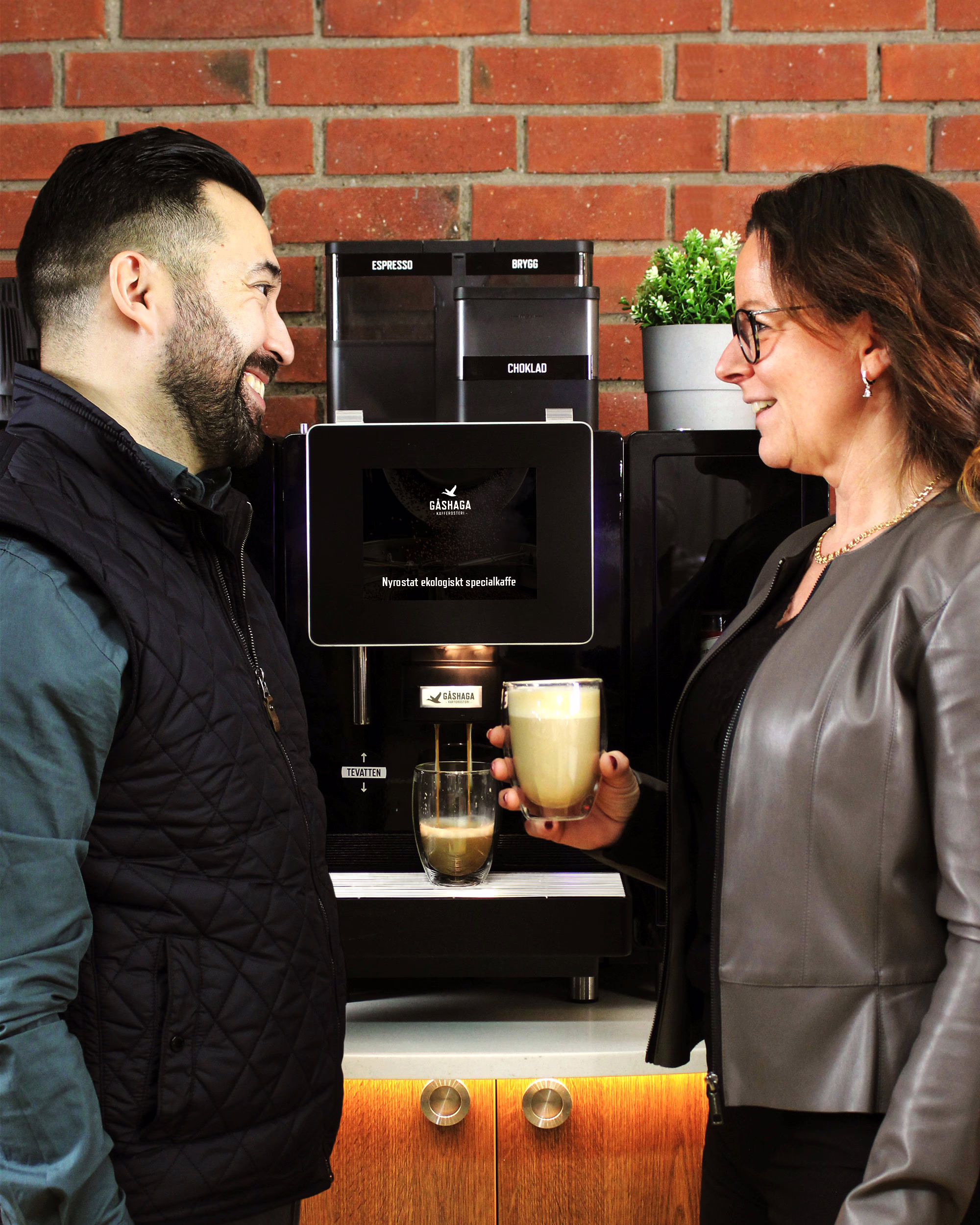 Kollegor vid kaffemaskin väntar på gott kaffe