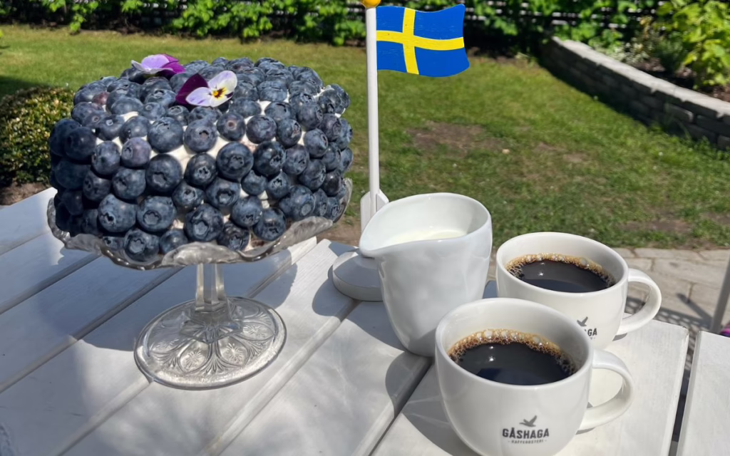Nationaldagstårta med choklad, kaffe och blåbär, med svensk flagga, mjölkkanna och bryggkaffe Sombra